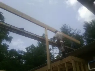 Carpenter setting a ridge beam over a new addition frame — Ice Dam Removal by Roofing Brothers in Tazewell