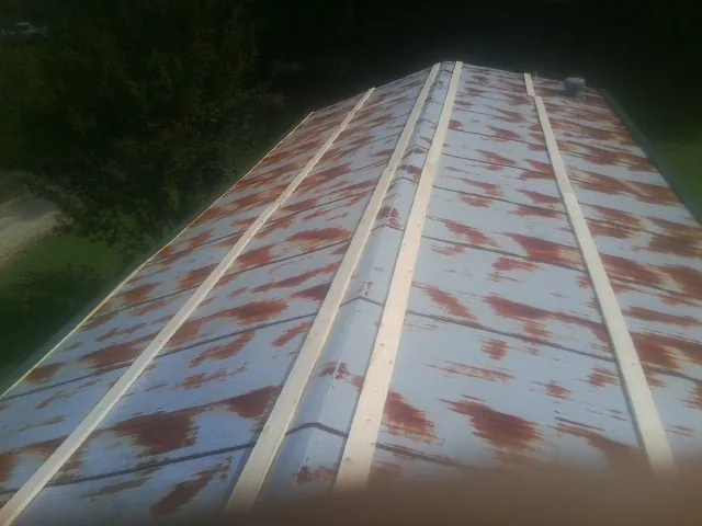 Rusted metal roof panels with new wood purlins before replacement — Storm Damage Roof Repair in Tazewell by Roofing Brothers