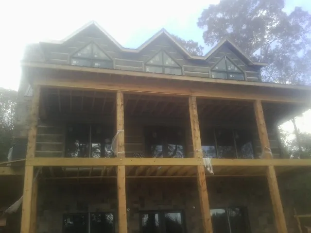 Dormers and porch framing on a large log home under construction — Roof Coating work by our crew in Tazewell