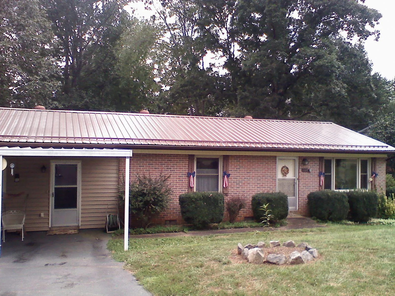 Bronze metal roof and carport on a brick ranch home — Roof Repair work by our crew in Tazewell