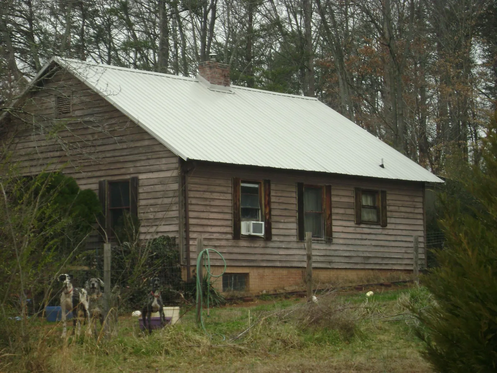 White metal roof on an old wood sided farmhouse, from a Metal Roof Installation job in Tazewell